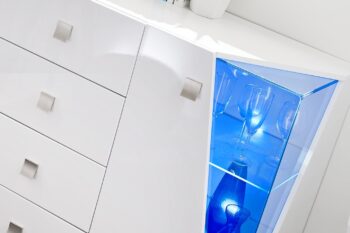 Komoda ENGY výniká svojím dizajnom.Komoda má netradičné rohové zasklenie a vďaka LED osvetleniu budú zvýraznené Vaše oblubené dekorácie alebo spomienkové predmety.Komoda je dvojvedverová za ktorými su dve sklenené poličky, v strede komody sa nachádzaju 4 praktické zásuvky.Kovové nožičky a úchyty dodajú ďalšie plus k modernému dizajnu.Farebné prevedenie:biela/biely lesk.Komodu môžete skombinovať s ostatnými prvkami zostavy ENGY a vytvoriť súdržny priestor obývacej izby.Rozmery (š/v/h):(150/100/45)cm.Dodávame v demonte, pričom montáž je veľmi jednoduchá.