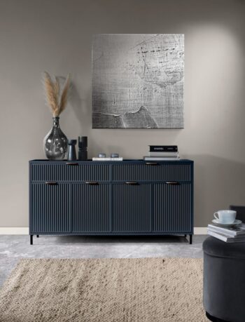 Široká komoda LS1 z kolekcie GRACE STYLES. Praktická veľká komoda, ktorá zaujme nielen moderným dizajnom, ale aj funkčnosťou. Má praktické zásuvky a skrinky, ktoré vám umožnia pohodlne usporiadať priestor.Rozmery: 165,3 x 86 x 40,6 cm.Dostupné v jednej z dvoch farieb: kašmír alebo indigoVlastnosti produktu:doska – 18mm laminovaná nábytková doskapredná strana – 18mm MDF doskahrana – ABS dyhazadná strana – HDF doskarukoväte - kovovépánty – kovové s mechanizmom tichého zatváranianohy – čierny kov – výška 12 cmKolekcia nábytku GRACE STYLES je dostupná v dvoch farbách a je len na vás, ktorú si vyberiete. Či už je to prírodná teplá kašmírová farba, ktorá je elegantná a hodí sa do každého interiéru, alebo výraznejšia indigo farba s úchytkami v medenej farbe. Nábytok je zdobený vzorom na čelách v podobe frézovaných drážok. Všetok nábytok z tejto kolekcie je na čiernych kovových nožičkách.Sektor GRACE STYLES v sebe spája štýly v interiéri.Jednoduché a funkčné tvary sa budú dobre hodiť do obývačky, spálne aj jedálne.Moderné farby, ktoré sú aktuálnym hitom pri tvorbe dizajnov v nových domácnostiach.Kovové, čierne nohy dodávajú miestnostiam ľahkosť a priestor.Nábytok dodávame v demonte. 