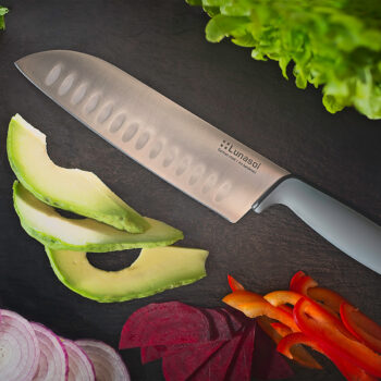 Podľa japonskej receptúry Nôž Santoku s čepeľou dlhou 17,8 cm je podľa Japoncov skvelý na 3 činnosti – krájanie, sekanie a drvenie. Môže za to práve čepeľ, ktorá je dostatočne široká, ale aj mierne hrubšia. A do jej tela sme pridali aj pár rýh. Keď s ňou krájate mrkvu či cuketu, nelepí sa vám na nôž, ale padá na pracovnú dosku. Širokú čepeľ zároveň využijete aj ako lopatku – naberiete nakrájané mäso či zeleninu a vhodíte do hrnca. Čepele nožov Basic sú vyrobené z kvalitnej nemeckej ocele a do plastovej rúčky sú zapustené – vďaka tomu je spoj veľmi pevný. Rúčky sú potiahnuté vrstvou gumy, preto sa vám v rukách nebudú šmýkať. Nože sú zabalené v papierovej kartičke s priehľadnou plastovou časťou na čepeli. Teší nás, že už pri línii Basic vieme garantovať vynikajúcu kvalitu.