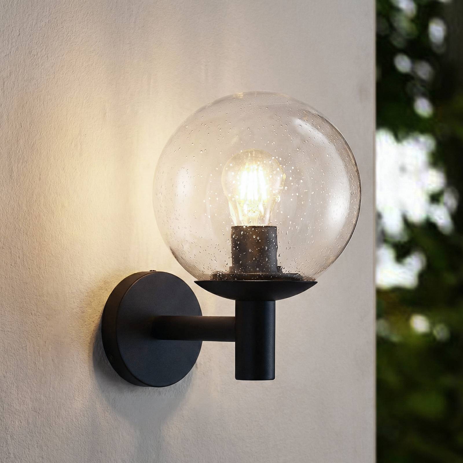 Lindby Vonkajšie nástenné svietidlo Dangan, čierne/čisté, sklo, Ø 20 cm Lindby Vonkajšie nástenné svietidlo Dangan, čierne/čisté, sklo, Ø 20 cm